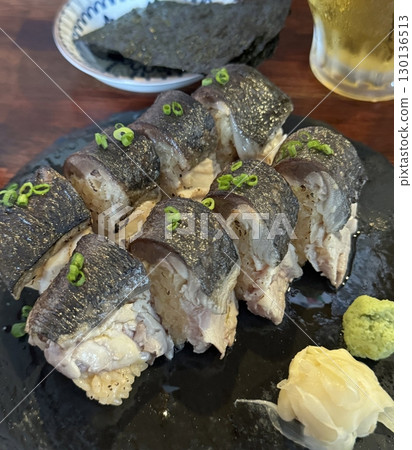 An assortment of fresh sushi, artfully arranged with a variety of toppings and vibrant colors. This traditional Japanese dish combines vinegared rice, seafood, and vegetables for an experience. 130136513