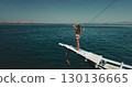 Aerial drone footage of a beautiful tourist enjoying the stunning landscape of Komodo National Park from a traditional Indonesian boat, capturing the essence of tropical adventure and wanderlust 130136665