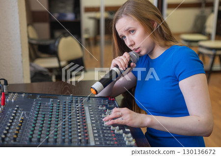 Young woman mixing live sound. Girl recording a song in the studio. Young woman mixing live sound. Girl recording a song in the studio. 130136672