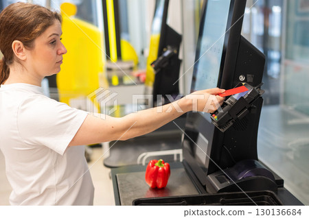 Woman paying with credit card at self-checkout. Woman paying with credit card at self-checkout. 130136684
