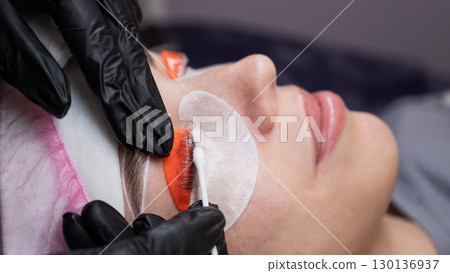 Caucasian woman undergoing eyelash lamination procedure.  130136937