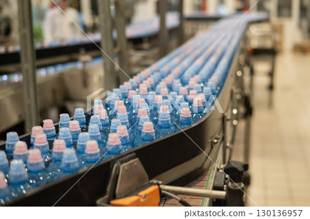 Bottled water on a conveyor belt at a factory. Bottled water on a conveyor belt at a factory. 130136957