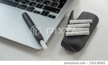 Tobacco heating system next to a laptop.  130136985