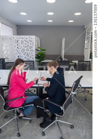 Man and woman shaking hands in office. Man and woman shaking hands in office. 130137009