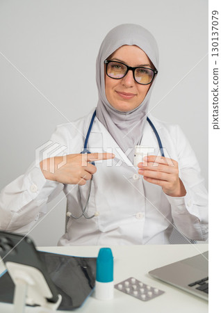 Female doctor in hijab recommends medications.  130137079