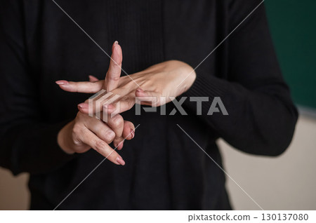 A woman shows the word integration in Russian sign language.  130137080