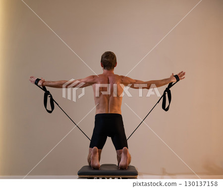 A man doing Pilates on a reformer.  130137158