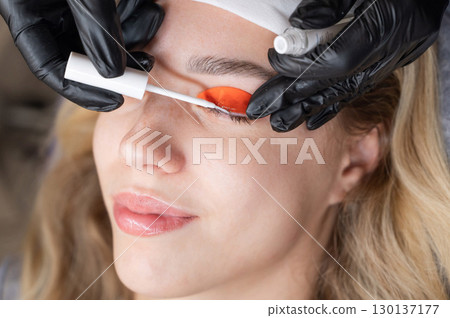 Caucasian woman undergoing eyelash lamination procedure. Caucasian woman undergoing eyelash lamination procedure. 130137177
