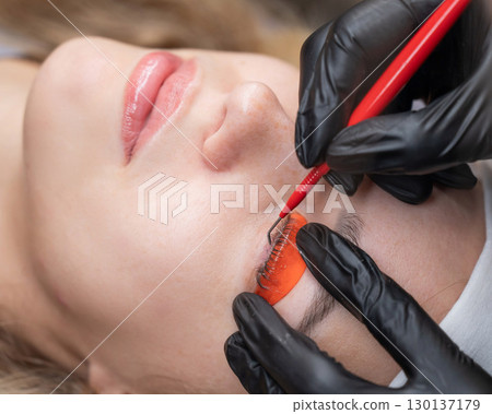 Caucasian woman undergoing eyelash lamination procedure. Caucasian woman undergoing eyelash lamination procedure. 130137179