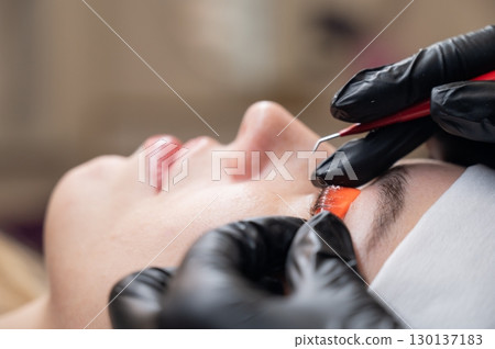Caucasian woman undergoing eyelash lamination procedure.  130137183
