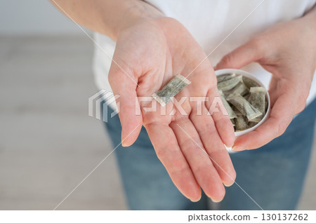 A woman holds a jar of chewing tobacco. A woman holds a jar of chewing tobacco. 130137262