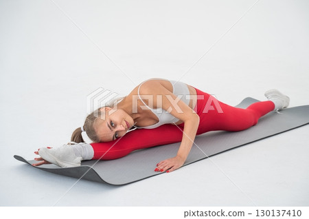 Young woman doing splits exercises on white background. 130137410