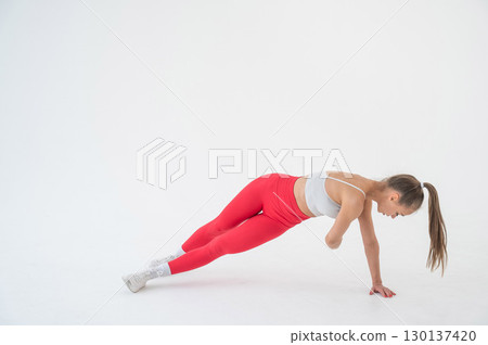 Young woman doing side plank and twists on white background. Young woman doing side plank and twists on white background. 130137420