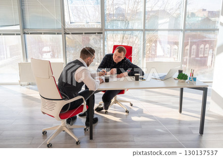 Two Caucasian men negotiating in an office.  130137537