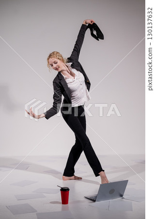 Barefoot ballerina dancing in business suit on white background.  130137632