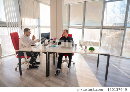 Two Caucasian men working in an office.  130137649
