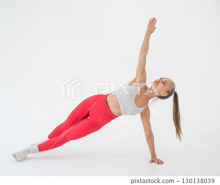 Young woman doing side plank on white background. Young woman doing side plank on white background. 130138039