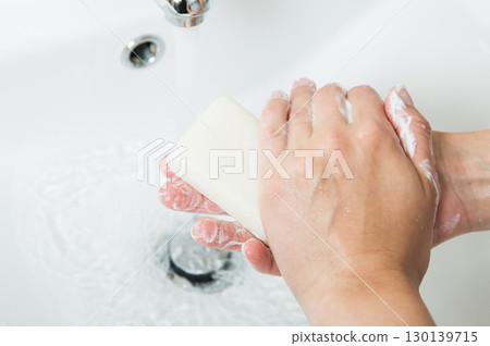 Thorough handwashing technique with soap and running water demonstrating proper hygiene protocol in clean bathroom sink Thorough handwashing technique with soap and running water demonstrating proper hygiene protocol in clean bathroom sink 130139715