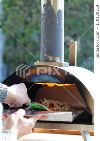 Bake pizza in an oven 130139914