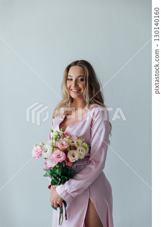 Blonde smiling in summer dress with bouquet of spring flowers Blonde smiling in summer dress with bouquet of spring flowers 130140160
