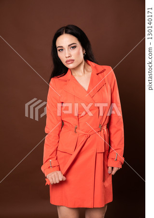 Portrait of a beautiful fashionable brunette woman in a red summer dress 130140171