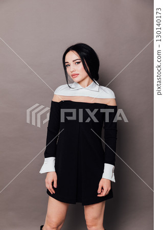 Portrait of a fashion brunette woman in a black summer dress on a white background 130140173