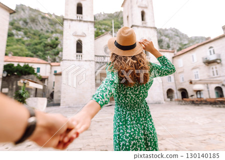 Follow me concept and traveling together. Girl traveler wearing dress, holds the boyfriend's hand Follow me concept and traveling together. Girl traveler wearing dress, holds the boyfriend's hand 130140185