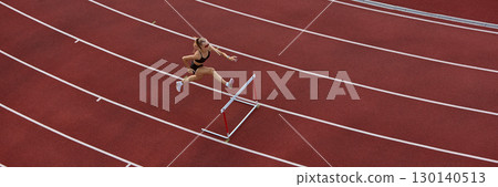 Female athlete hurdling viewed from above on red track. Banner Female athlete hurdling viewed from above on red track. Banner 130140513