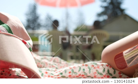 Cap with Italian flag colors and water bottle lying near an outdoor swimming pool, summer sunlight, leisure and hydration theme Cap with Italian flag colors and water bottle lying near an outdoor swimming pool, summer sunlight, leisure and hydration theme 130141024