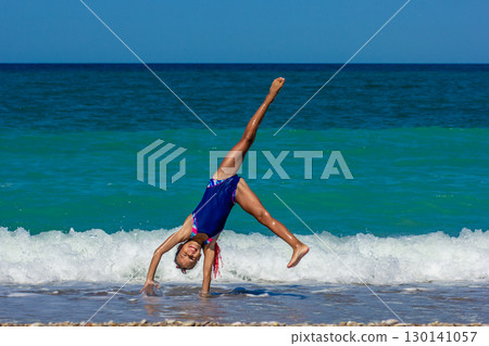 Girl Doing a Cartwheel on the Beach Girl Doing a Cartwheel on the Beach 130141057