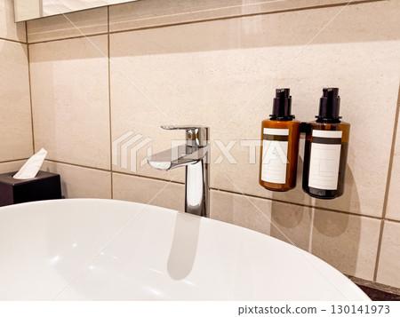 Wall-mounted soap and shampoo dispensers in hotel bathroom. Hygiene, sanitation, and service in modern hospitality. Wall-mounted soap and shampoo dispensers in hotel bathroom. Hygiene, sanitation, and service in modern hospitality. 130141973