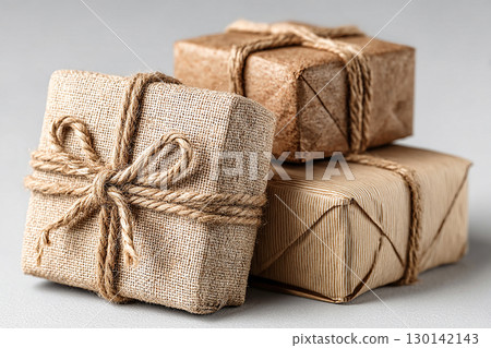 Holiday gift. Minimalist brown Kraft Gift Box with twine bow on white background. Holiday gift. Minimalist brown Kraft Gift Box with twine bow on white background. 130142143