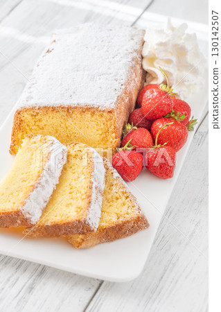 Pound Cake Slices with Whipped Cream and Strawberries on Elegant White Plate 130142507