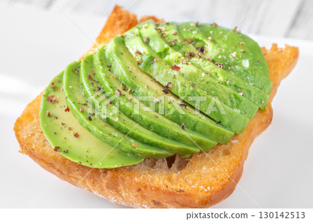 Toasted ciabatta sandwich with sliced avocado served on a clean plate 130142513
