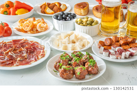 Spanish Tapas Spread with Jamon, Cheese, Shrimp, Olives, and Chilled Beer 130142531