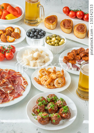 Spanish Tapas Spread with Jamon, Cheese, Shrimp, Olives, and Chilled Beer Spanish Tapas Spread with Jamon, Cheese, Shrimp, Olives, and Chilled Beer 130142533