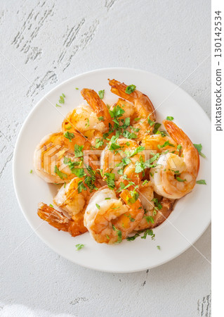 Golden Spanish Fried Shrimps Garnished with Fresh Parsley on White Background Plate Golden Spanish Fried Shrimps Garnished with Fresh Parsley on White Background Plate 130142534