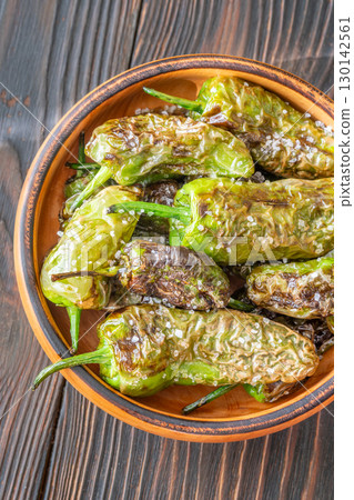 Terracotta bowl of Pimientos de Padron sprinkled with coarse sea salt 130142561