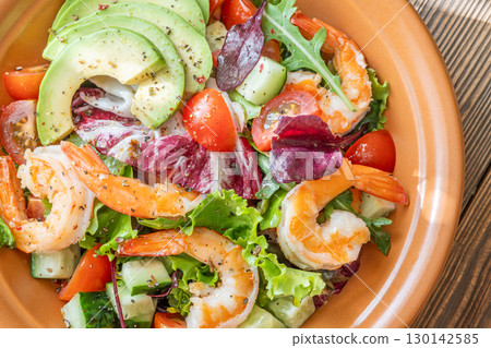 Fresh prawn avocado salad cherry tomatoes wooden table citrus dressing Fresh prawn avocado salad cherry tomatoes wooden table citrus dressing 130142585