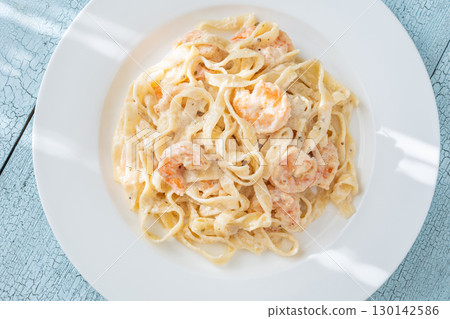 Creamy fettuccine shrimp pasta white plate savory sauce gourmet flavor 130142586