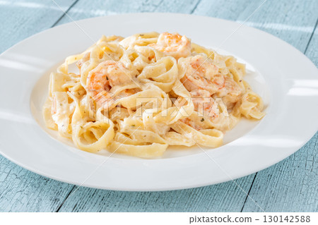 Creamy fettuccine shrimp pasta white plate savory sauce gourmet flavor Creamy fettuccine shrimp pasta white plate savory sauce gourmet flavor 130142588