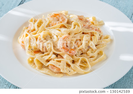Creamy fettuccine shrimp pasta white plate savory sauce gourmet flavor Creamy fettuccine shrimp pasta white plate savory sauce gourmet flavor 130142589