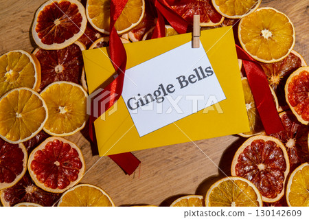 Greeting card with GINGLE BELLS text on handmade Christmas wreath. Festive mood new year celebration. Postcard decoration decor Greeting card with GINGLE BELLS text on handmade Christmas wreath. Festive mood new year celebration. Postcard decoration decor 130142609