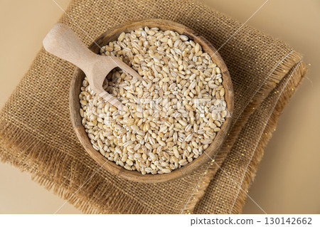 Pearl barley in neutral beige background. Whole spelt grain species. High protein fiber-rich vegan plant based food ingredient. Gluten free superfood healthy nutritional dietary alternative 130142662