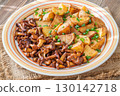 Fried potatoes chanterelle mushrooms seasoned paprika rustic wooden table plate 130142718