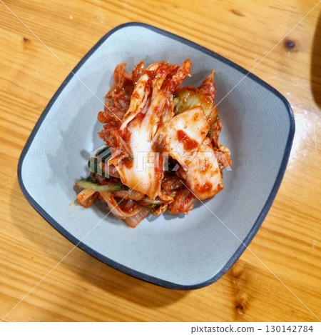 The images show a small bowl of kimchi, a classic Korean side dish of fermented and spiced napa cabbage. 130142784