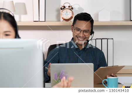 Smiling Call Center Employee Assisting Customers with Headset 130143410