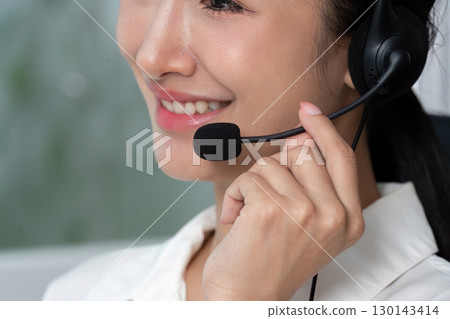 Call Center Agent Smiling While Holding Headset Call Center Agent Smiling While Holding Headset 130143414