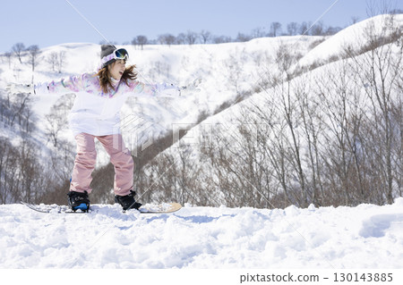 Cute woman enjoying snowboarding Cute woman enjoying snowboarding 130143885