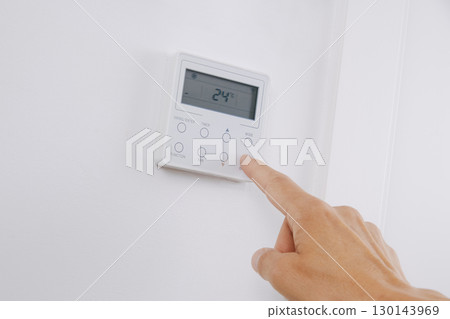 man switches the air conditioning on or off 130143969